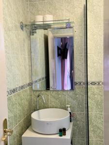 uma casa de banho com um lavatório e um espelho em Villa Guci em Ulcinj