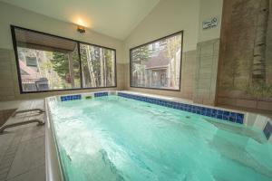 een groot zwembad met blauwe tegels in de badkamer bij Pines 2047 in Keystone