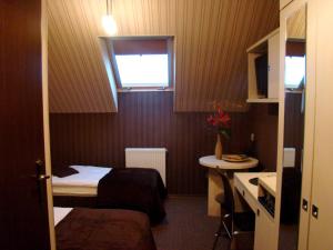 Cette petite chambre comprend 2 lits et un lavabo. dans l'établissement Apart A2 Bezobsługowy 24h Poznań, à Poznań