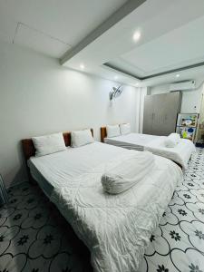 a bedroom with two beds with white sheets at Vika Homestay in Ho Chi Minh City
