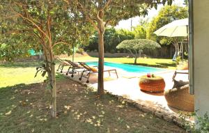 a pool with chairs and an umbrella and trees at Mancareste in Paradou +26 photos