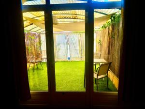 ルシヨンにあるDomaine Plan des Devensのテーブルと椅子が備わる窓から庭の景色を望めます。