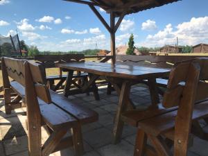 a wooden picnic table and chairs under an umbrella at Domki na Wzgórzu in Ryn