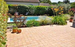 a garden with a swimming pool and some plants at Villa La Coupe D'or in Avignon