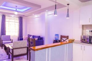 a kitchen and living room with a table and chairs at The pine 1 bedroom house California plaza in Nanyuki