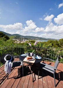 Una mesa con un plato de comida en una terraza. en Piscine chauffée et magnifique vue mer! à10 mns de la plage & du centre!, en Cavalaire-sur-Mer