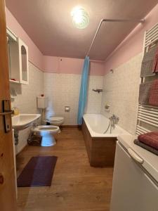 uma casa de banho com uma banheira, um WC e um lavatório. em Maison Jenny em Aosta