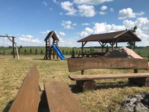 a park with a playground with a bench and a slide at Domki na Wzgórzu in Ryn +7 photos