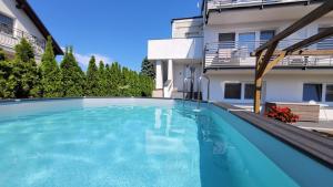 a swimming pool in front of a house at GoldenApart Willa -Apartamenty z dwiema sypialniami, basen in Krynica Morska