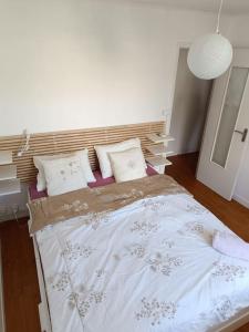 ein Schlafzimmer mit einem großen Bett mit weißen Laken und Kissen in der Unterkunft Maison cœur de village 300 m des gorges du gardon in Collias + 10 Fotos