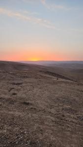 an empty field with the sunset in the background at Sun, Mountain & Adventure in Arad