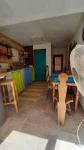 a room with a table and chairs and a blue door at Casa Estrella Cave Apartment in Baza