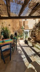 a patio with a table and a stone wall at Casa Estrella Cave Apartment in Baza