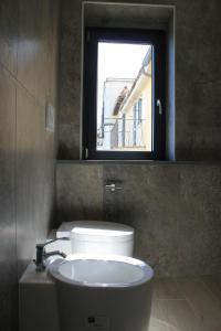 W łazience znajduje się toaleta, umywalka i lustro. w obiekcie Like Lake Martana w mieście Marta