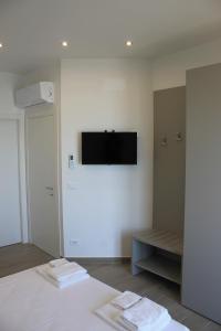 Pokój z łóżkiem i telewizorem na ścianie w obiekcie Like Lake Martana w mieście Marta