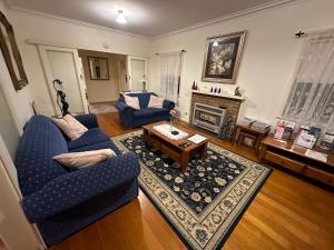 un soggiorno con 2 sedie blu e un tavolino da caffè di Admurraya House Bed & Breakfast a Rutherglen