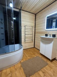 een badkamer met een douche, een bad en een wastafel bij Верховинський водограй in Synevyrsʼka Polyana