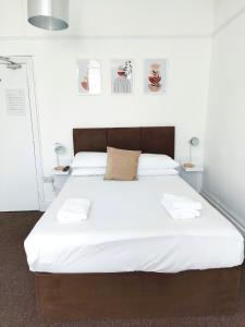 a bedroom with a large bed with white sheets at Horizon in Brighton & Hove