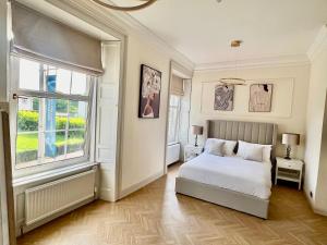 a bedroom with a white bed and a window at Flora in ApartNest Auchterarder in Auchterarder