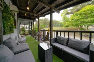 una veranda schermata con divani e amaca di Private hot-spring Villa in Kusatsu a Kusatsu