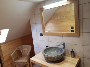 La salle de bains est pourvue d'un lavabo et d'un miroir sur une table. dans l'établissement La Girandole Chambre d'hôtes, à Arvieux