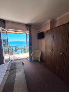 1 dormitorio con 1 cama y balcón con vistas. en VILLA VOLOSKO with private parking and breakfast,seaview, en Volosko