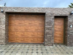 two wooden garage doors on a brick building at Villa with a pool & close to the sea in Baku