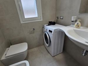 a bathroom with a washing machine and a sink at Grey House 5 100mt dal mare in Tortoreto Lido +14 photos