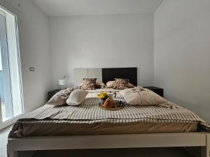 a bed with a bowl of flowers on it at Grey House 5 100mt dal mare in Tortoreto Lido