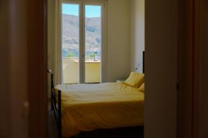een slaapkamer met een bed en een raam bij Villa Oliveto apartments in Oliveto Lario
