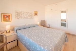 a bedroom with a bed and a table and a window at Inspira by Unik Vacation in Torredembarra