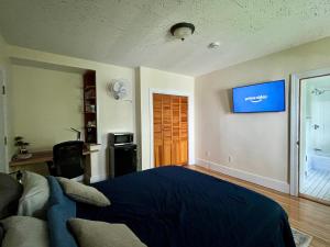 a bedroom with a bed and a tv on the wall at Traveler’s Den in Medford in Medford