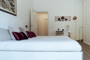 een slaapkamer met een groot wit bed met rode kussens bij Domus Clelia in Rome