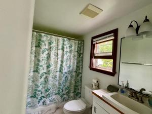 a bathroom with a toilet and a sink and a window at Traveler’s Den in Medford in Medford