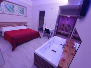 I due piccioncini suite في غروتاميناردا: غرفة نوم مع سرير وحوض استحمام