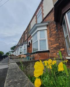 a brick house with yellow flowers in front of it at Potts House - Hornsea on the Yorkshire coast in Hornsea