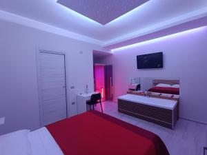 a bedroom with two beds and a desk and a tv at I Due Piccioncini Suite in Grottaminarda