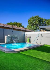 una piscina en un patio con césped verde en FB-Canatal Luxury Apartments, en Ciudad del Cabo