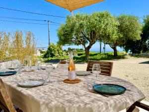 Villa SYAGRUS - Easy Home Booking في نيس: طاولة مع كؤوس وزجاجة من النبيذ عليها