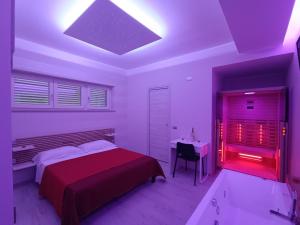 a bedroom with a bed and a desk with a red light at I Due Piccioncini Suite in Grottaminarda