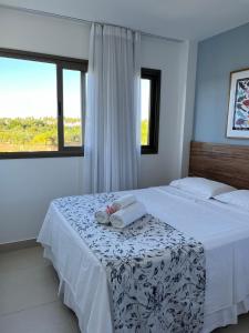 a bedroom with a bed with two towels and a window at O Paraíso que você merece in Praia do Forte +61 photos