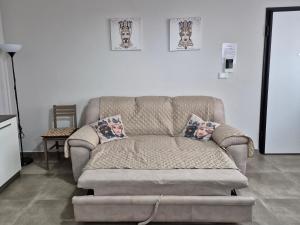 ein Sofa im Wohnzimmer mit zwei Kissen darauf in der Unterkunft A casa di Antonella in Portopalo