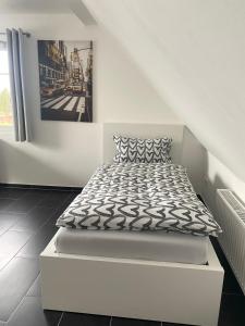 a white bed in a room with a picture on the wall at Apartment Sonnenschein in Allersberg