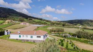 an aerial view of a white house in a field at Hydrangea House in Água de Pau