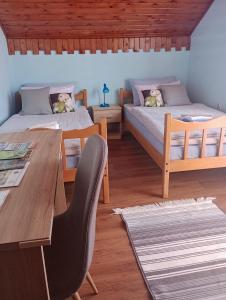 Dos camas en una habitación con mesa y sillas. en Holiday Home Nena, en Korenica