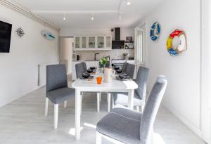 a dining room with a white table and chairs at Bista Eder in Pyla-sur-Mer