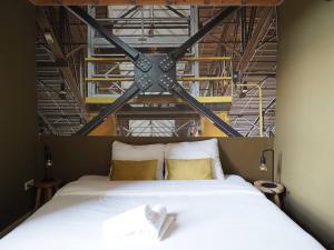 - une chambre avec un grand lit blanc et des oreillers jaunes dans l'établissement Hostel Roots, à Tilbourg