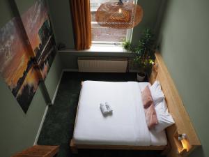 - un petit lit dans une chambre avec fenêtre dans l'établissement Hostel Roots, à Tilbourg