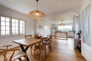 a kitchen and dining room with a wooden table and chairs at Hydrangea House in Água de Pau