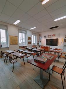 a classroom with tables and chairs in a classroom at L'école buissonnière in Laroque-dʼOlmes